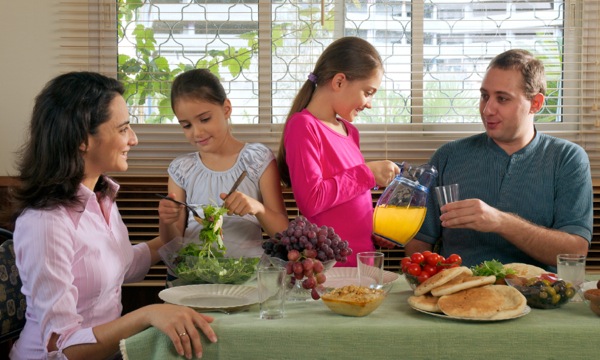 En lycklig familj äter mat tillsammans