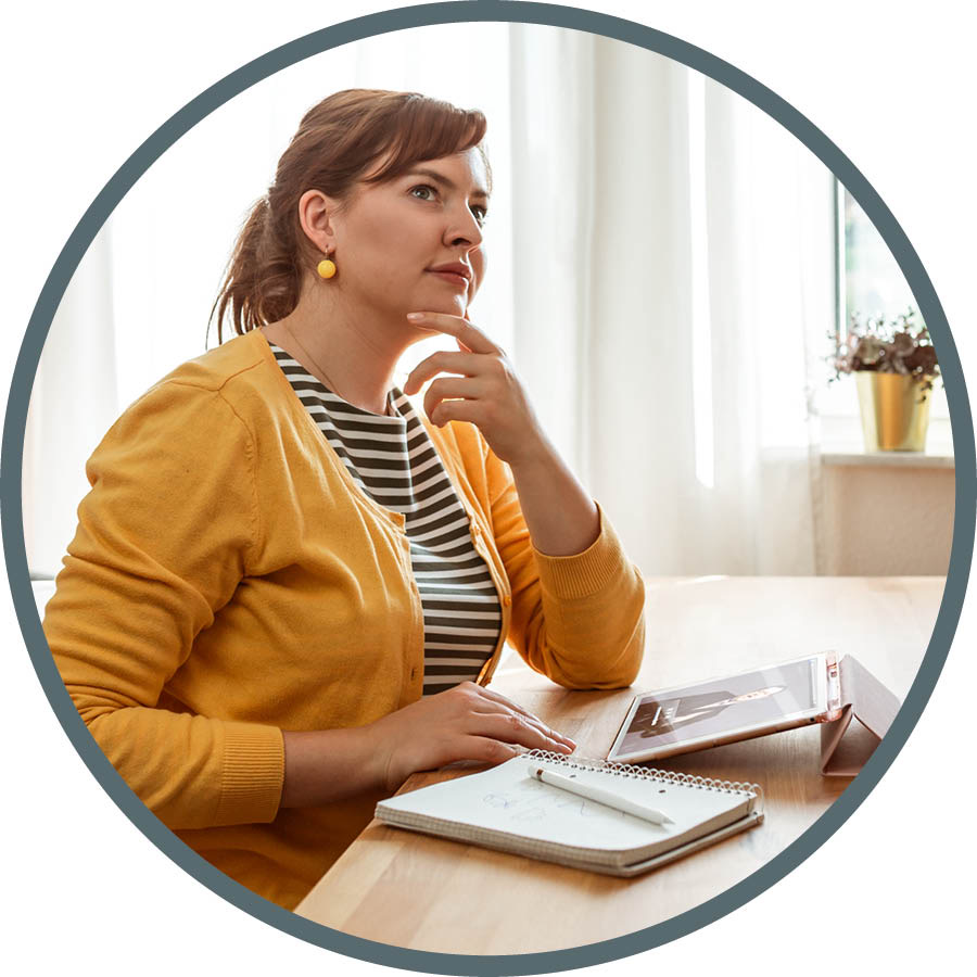 Kvinnan som studerar stannar upp och begrundar det hon har läst.