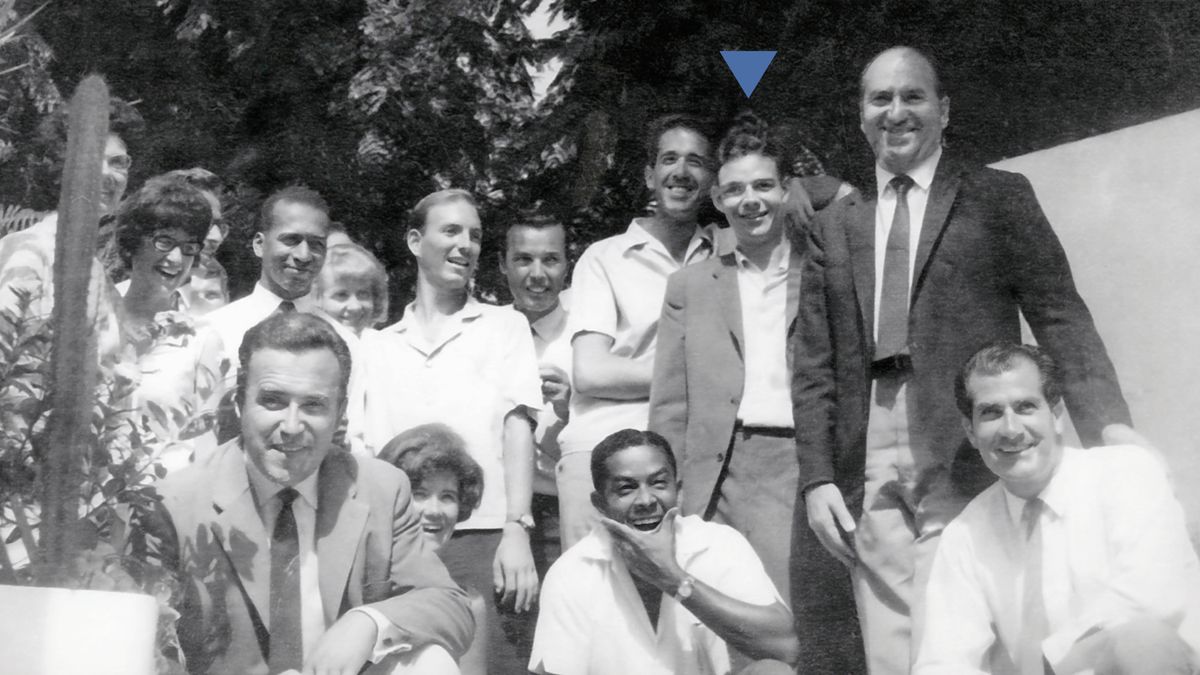 David birader bir grup kardeşle fotoğraf çekiliyor. Fotoğraftaki herkes gülümsüyor.