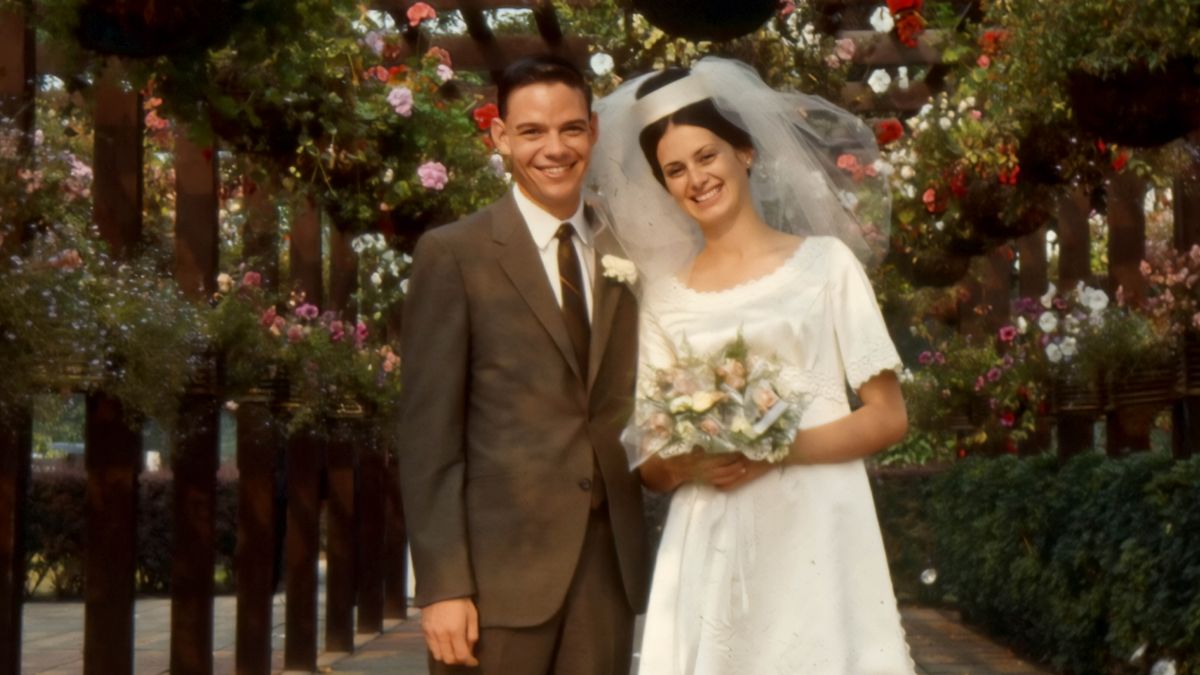 David ve Linda Splane üstü çiçeklerle kaplı bir yolda gülümsüyorlar.