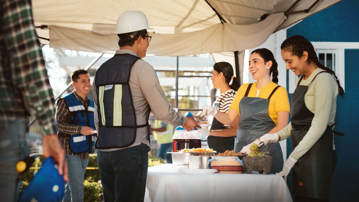 Üç kız kardeşimiz teokratik bir inşa projesinde sevinçle kardeşlere yemek servisi yapıyor.