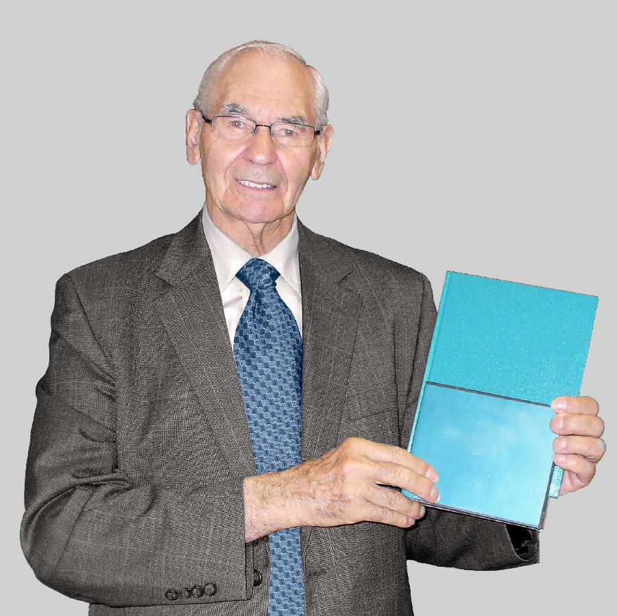 79 яшьлек Уолтер Маркин Пионерлар мәктәбе китабын һәм ишарәләр телендәге DVD дискны тотып тора