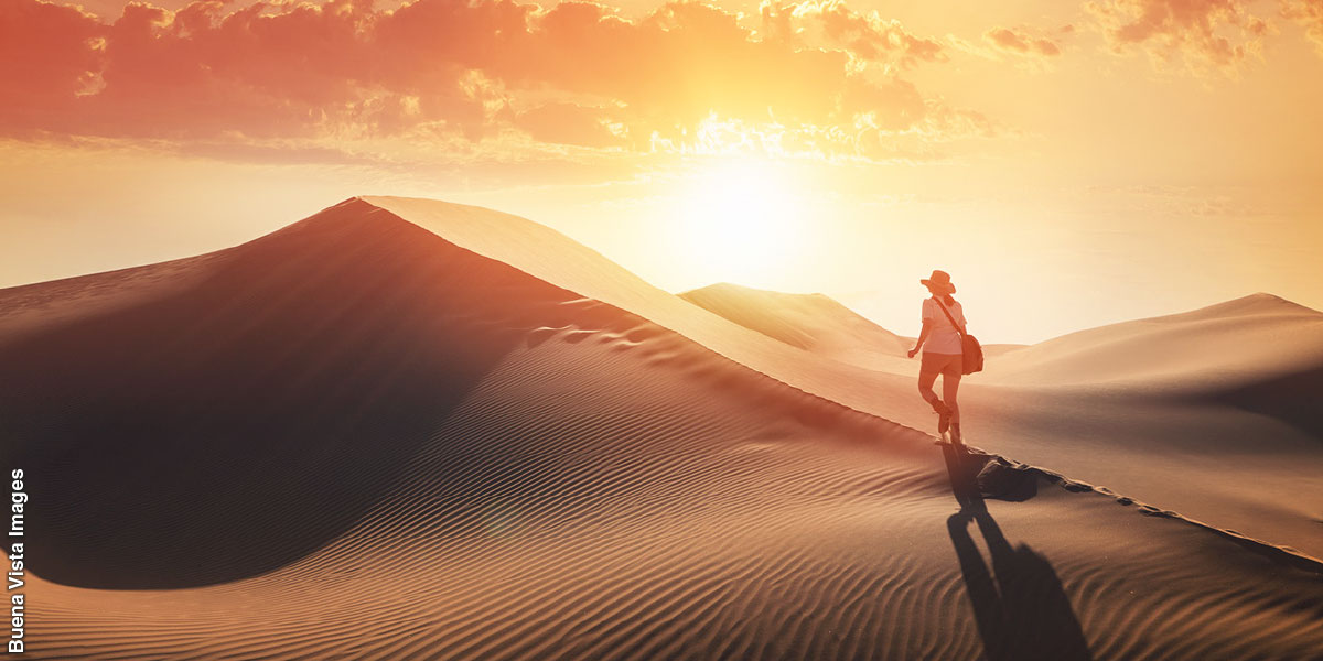 ایک عورت ریگستان سے گزر رہی ہے۔‏