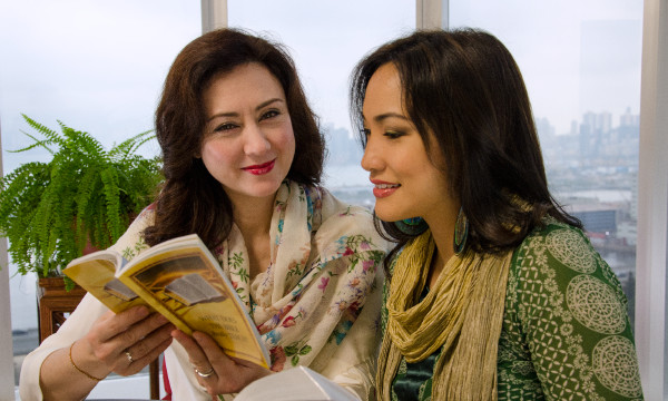 مینا ہونگ گوڈینزی ایک عورت کو بائبل کورس کرا رہی ہیں۔‏