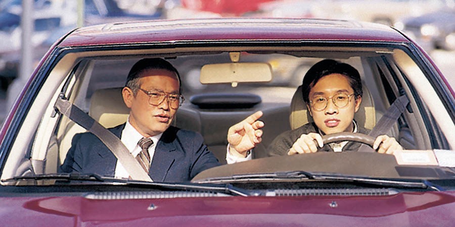 Một người đàn ông lái xe dưới sự hướng dẫn của một người thầy