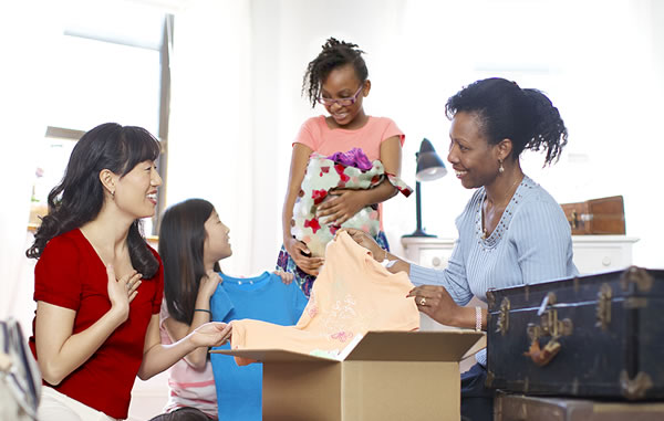 Một người mẹ đang cho quần áo cho một người mẹ khác