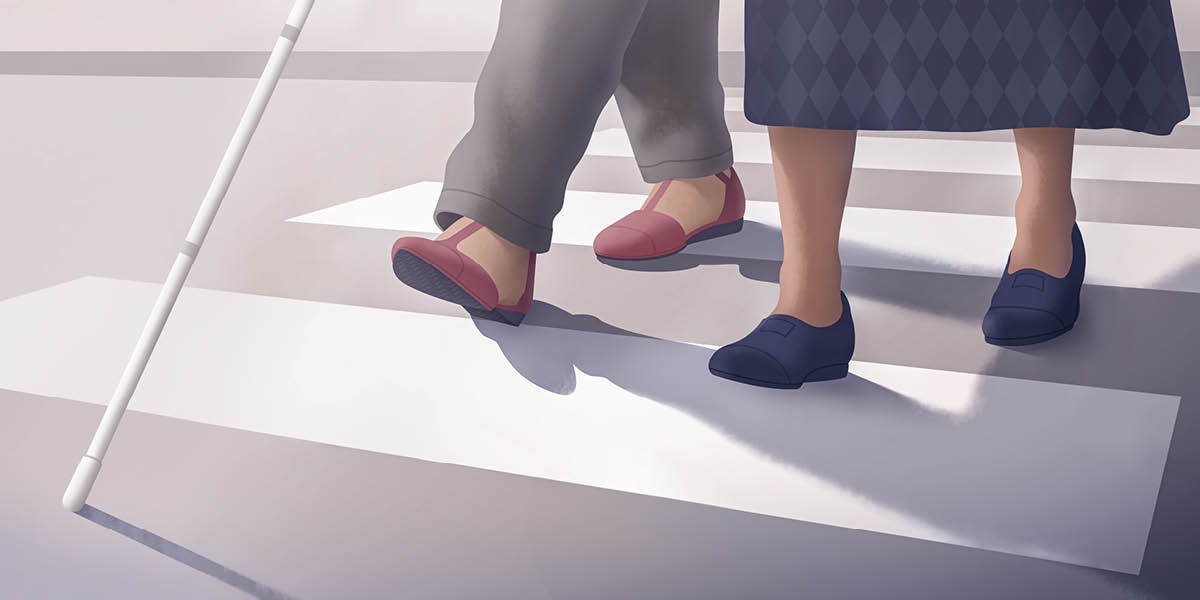 Arábìnrin kan ń mú obìnrin afọ́jú kan sọdá títì.