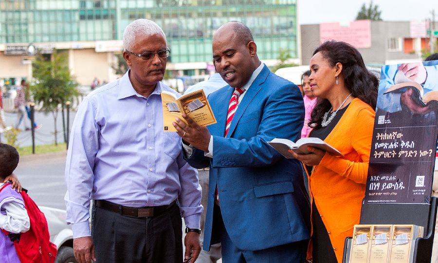 Àwọn Ẹlẹ́rìí Jèhófà dúró sẹ́gbẹ̀ẹ́ àtẹ ìwé nílùú Addis Ababa, wọ́n sì ń fi ìtẹ̀jáde lédè Amharic wàásù fún ọkùnrin kan